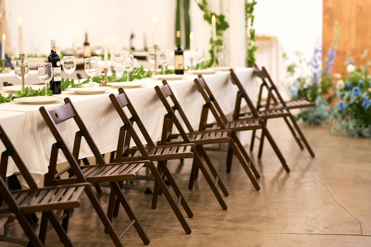 Beautifully decorated banquet table with floral accents and wooden chairs.
